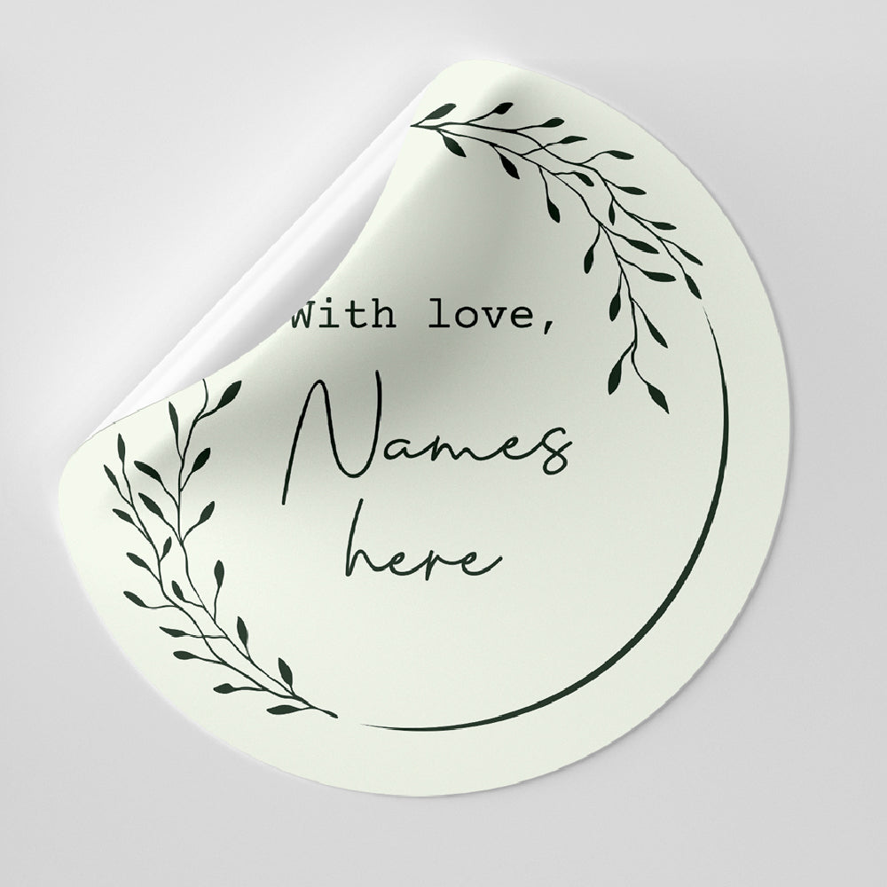 Round white sticker with black text and leaf design on a light gray background