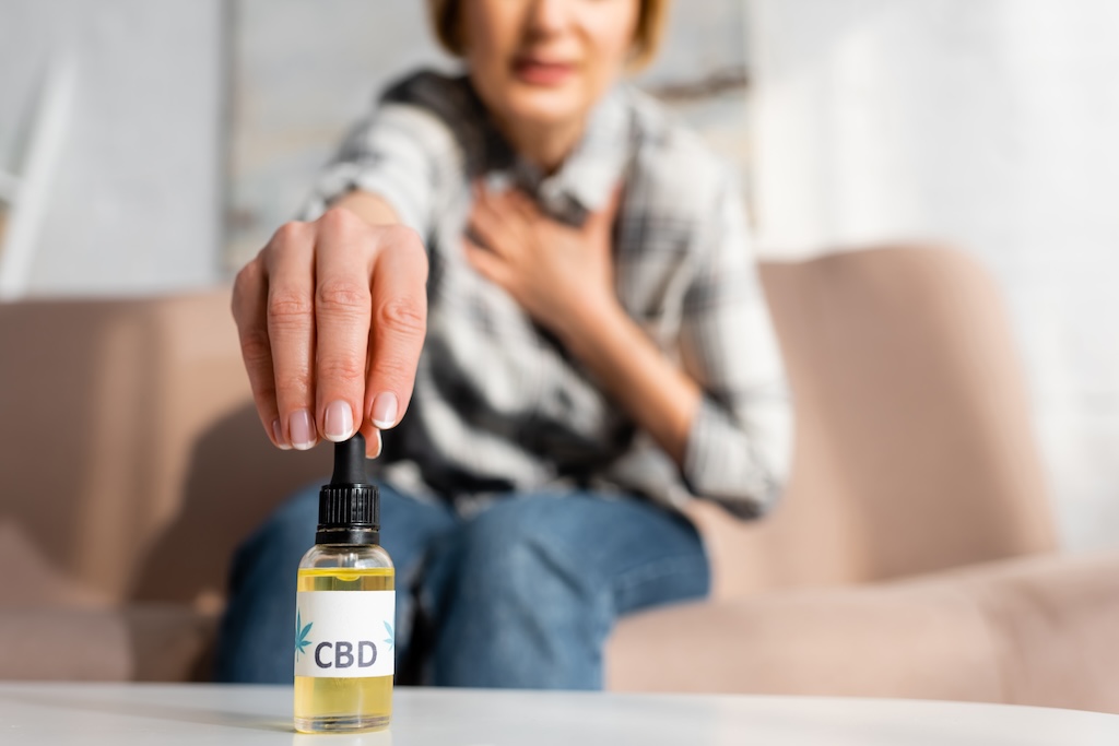 a woman tasting frosted kush cbd oil